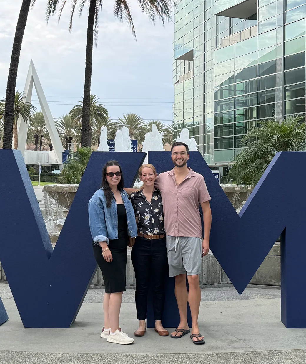 Three members of the Digital Empathy team outside the AVMA convention centre in Anaheim, in front of the giant AVMA letters.