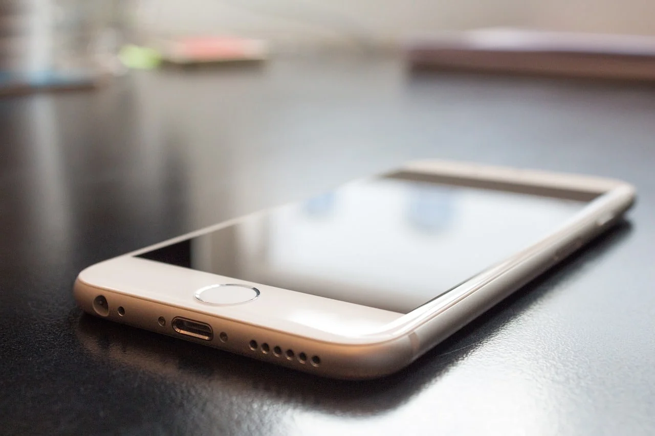 Smartphone lying face-up on a dark glossy desk