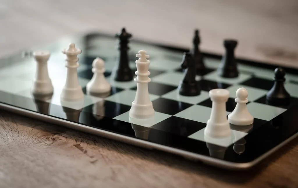 Chess pieces set up on a tablet screen displaying a chessboard