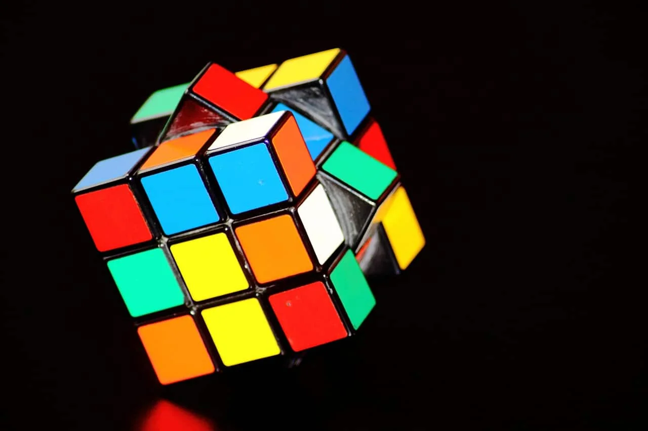 Colorful Rubik's cube, partially twisted, glowing against a black background